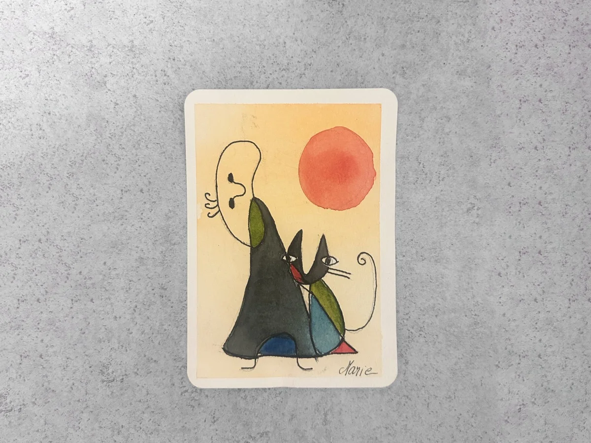 Marie Feutrier creating watercolor painting at desk with art supplies